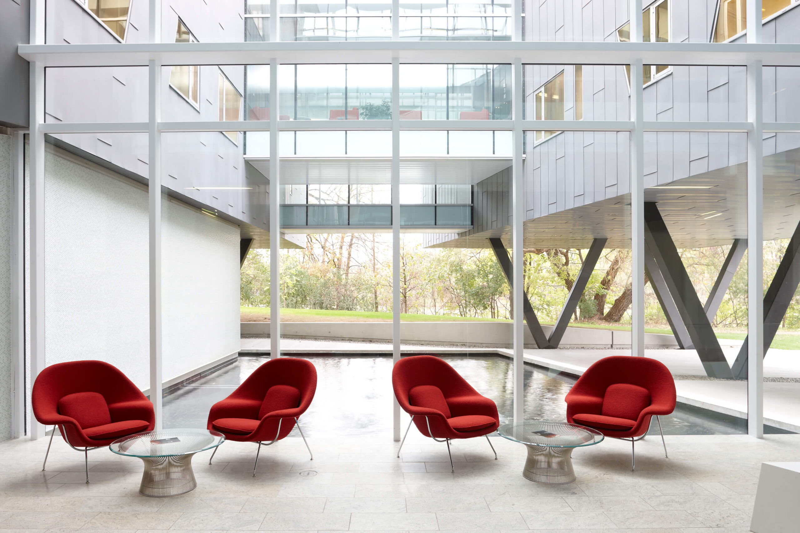 Womb Chair in red upholstery in a modern public space with big tall windows