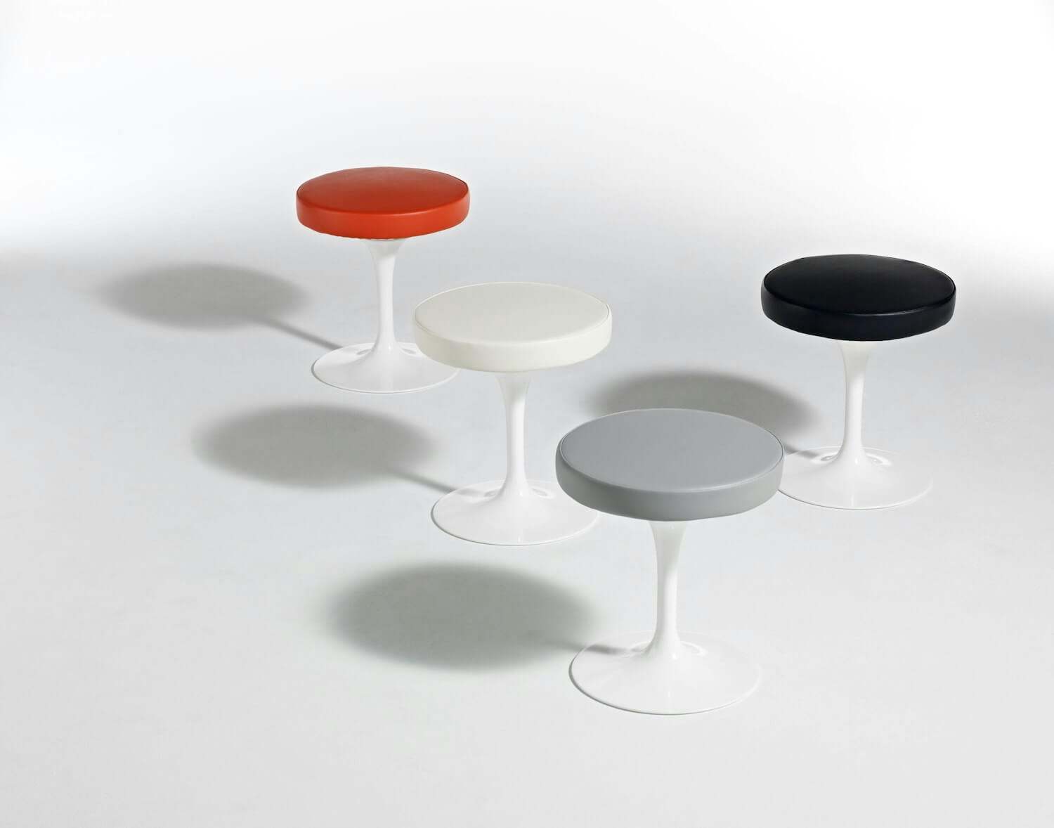 Tulip Side Stools in various colors in a white background