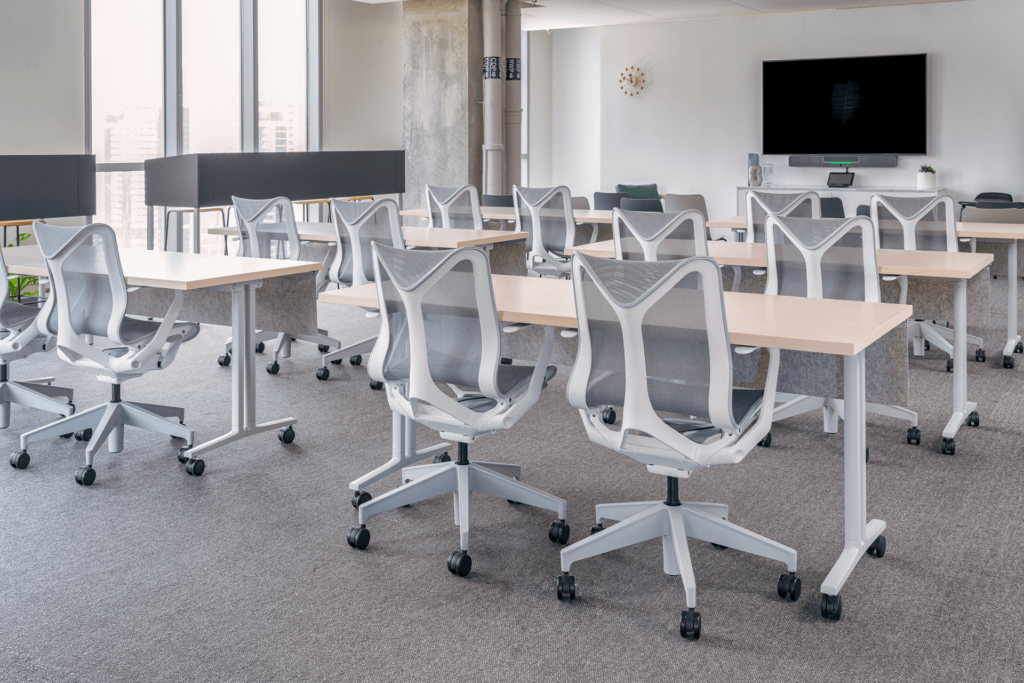 university classroom deaturing gray ergonomic chairs and white wood top table with caster wheels