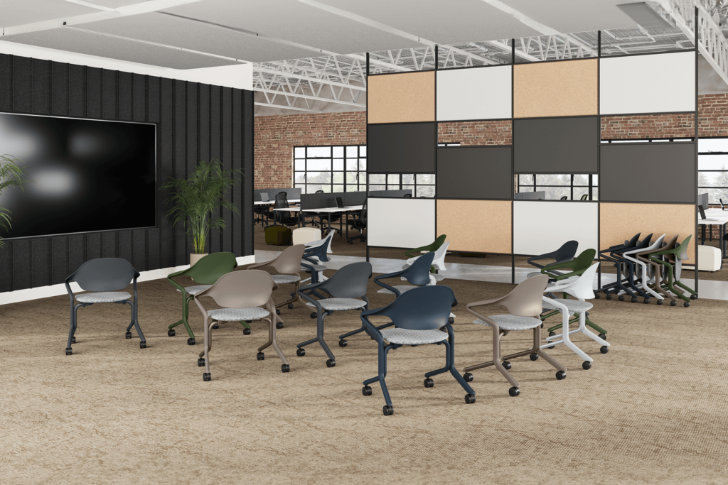 student stacking chairs at a university classroom with a big screen on the side