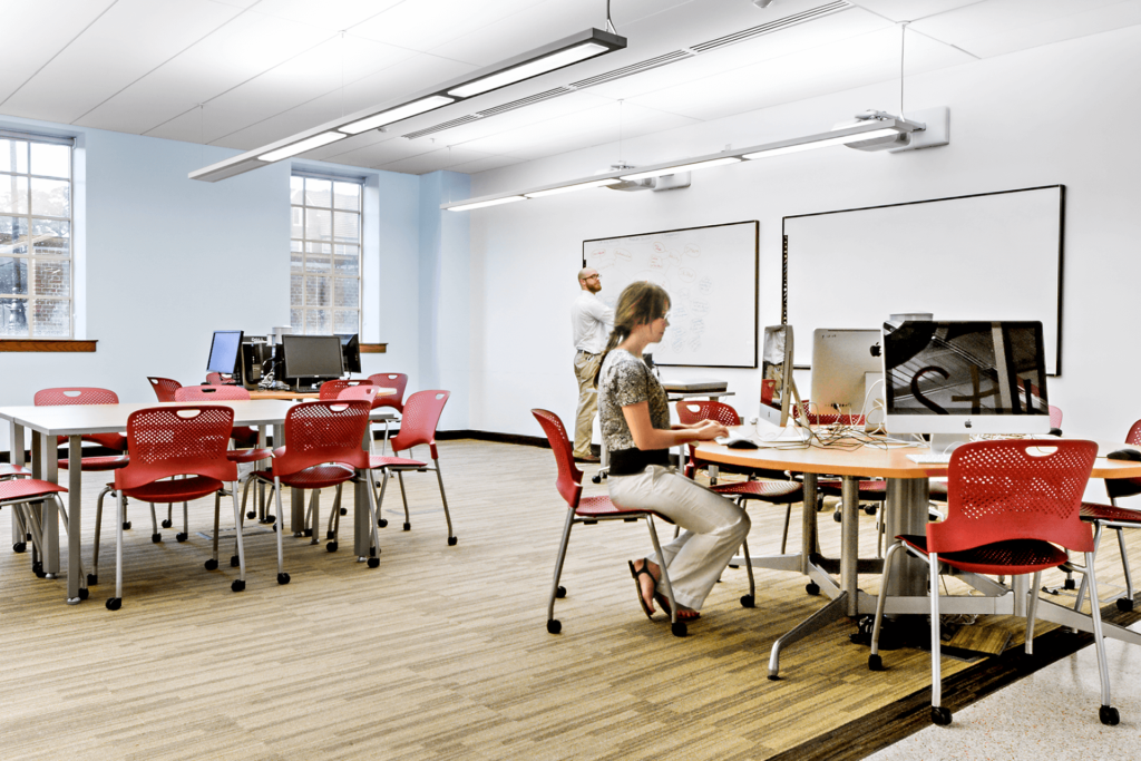 modern university classroom with red chairs and imac screens