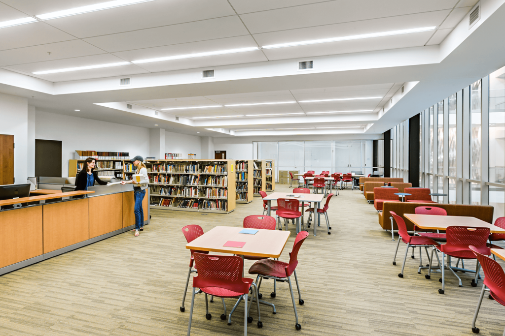 university campus library featuring red chairs and a reception area