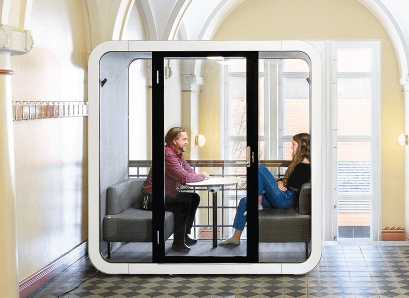 a teacher and a student in a soundproof pod at a university hall