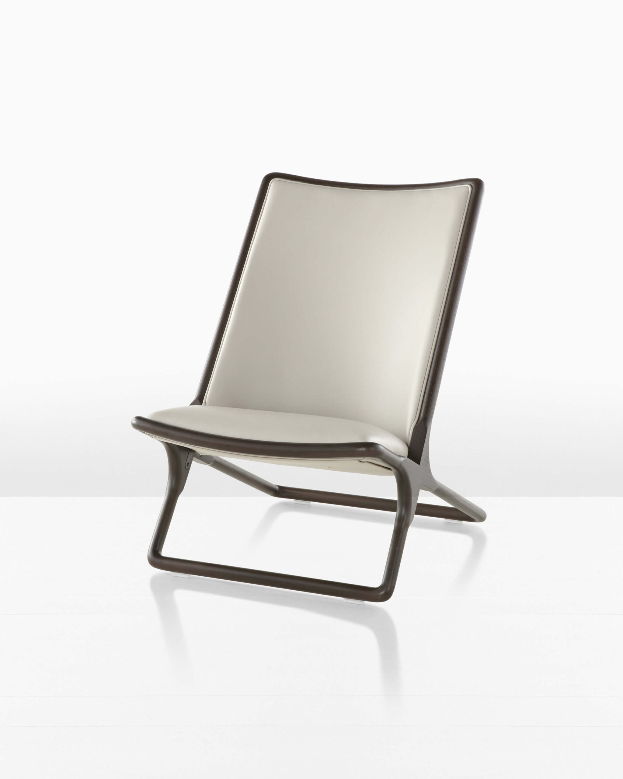 the front side angle of a Scissor Lounge Chair with cream upholstery and dark oak wooden frame in a white room