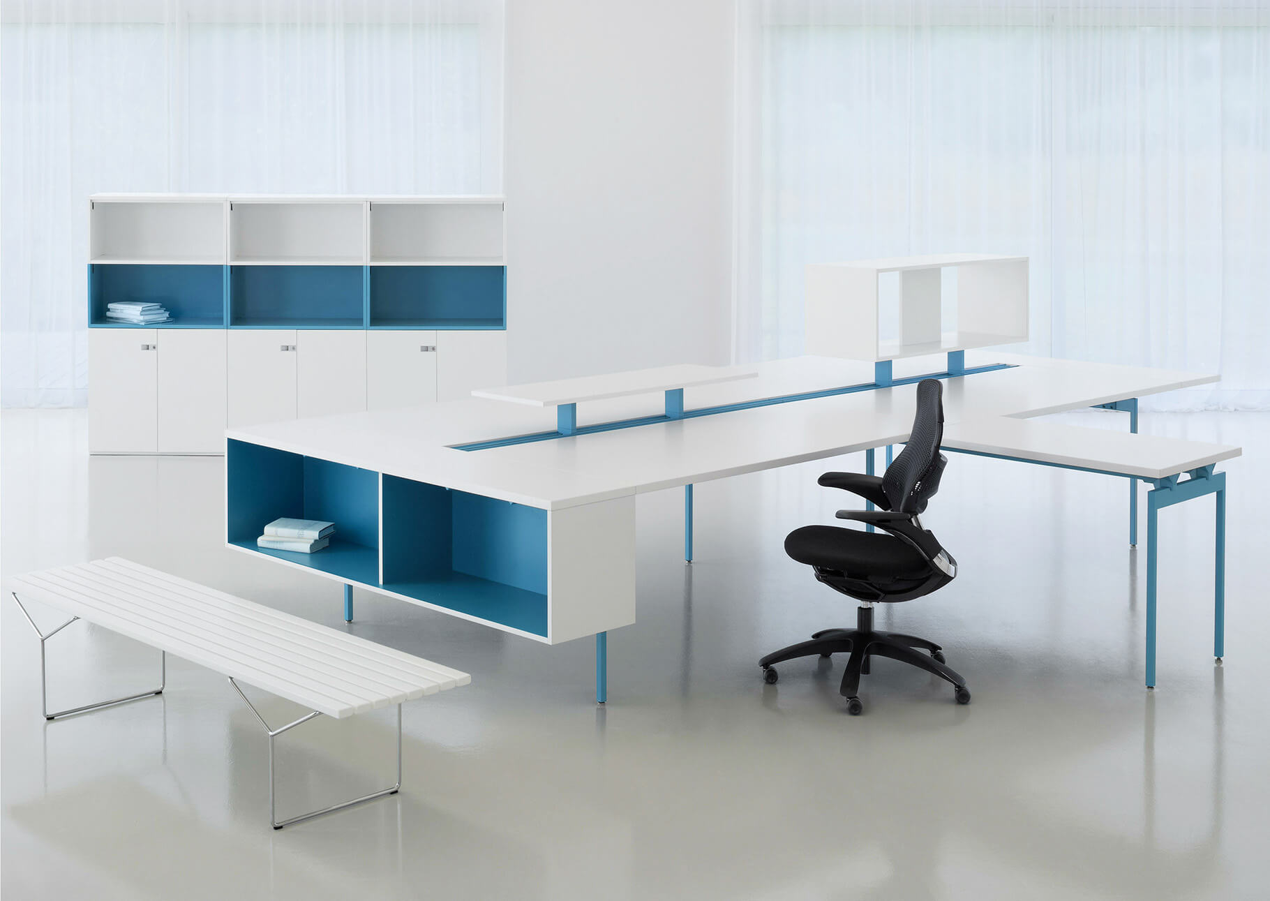 antenna workspaces in white and blue legs and drawerss in a white room