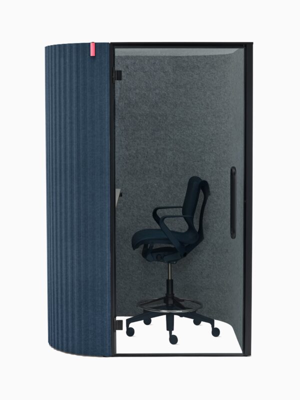 bay work pod by herman miller in dark blue colour and a chair inside in a white room