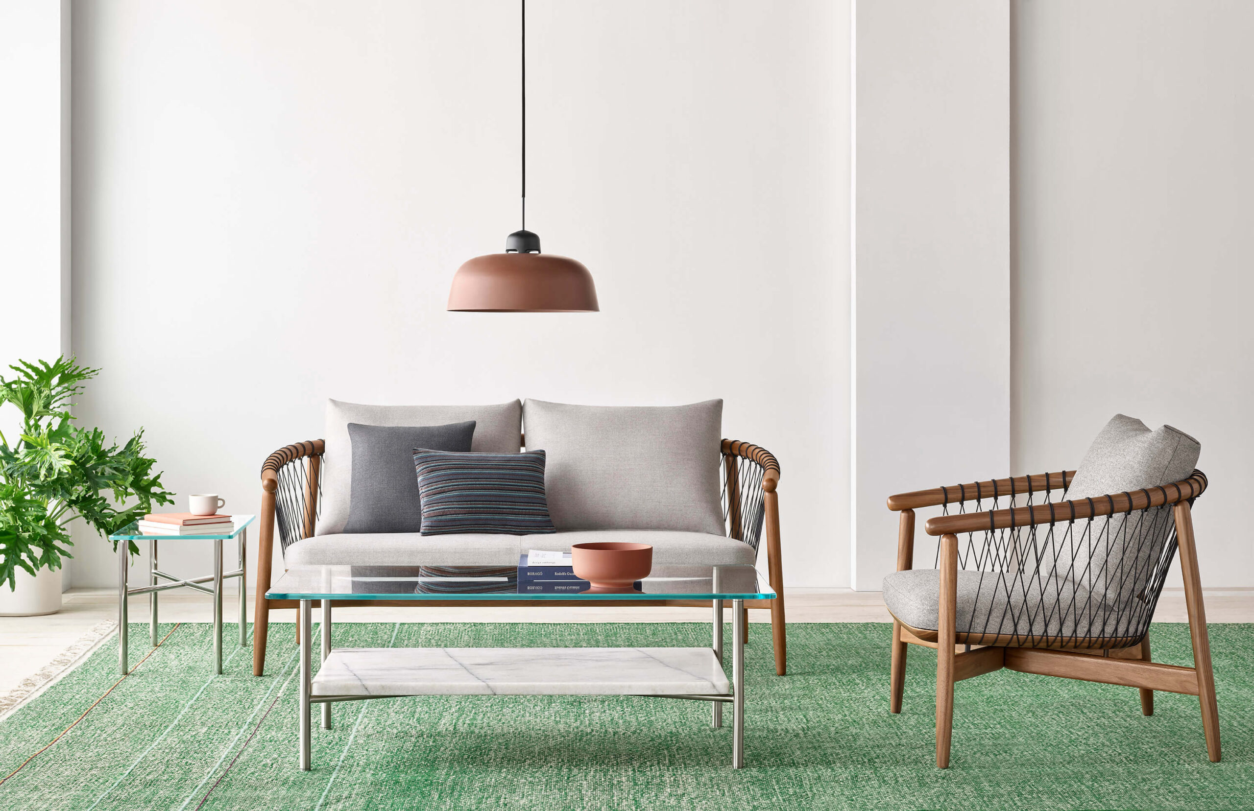 an elegant lounge area featuring a glass top Layer Side Table in the middle and cross hatch sofa and chairs around