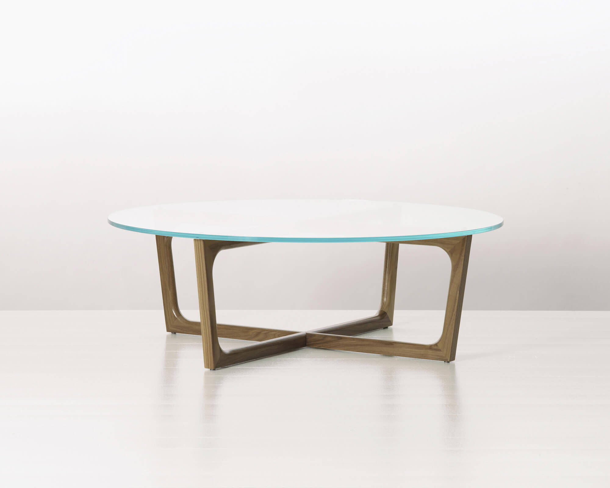 a rounded Loophole Side Table view with glass top and oak wood in a white room