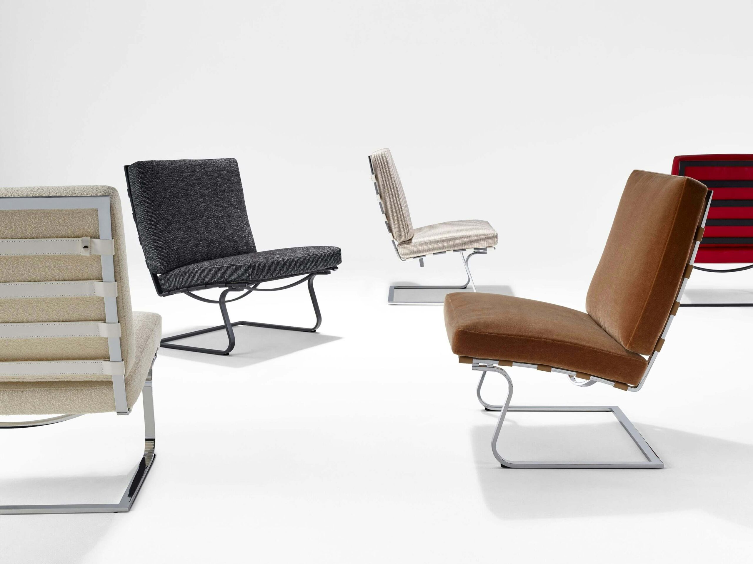 five Tugendhat Lounge Chair with different upholstery styles and polished aluminium frame in a white room
