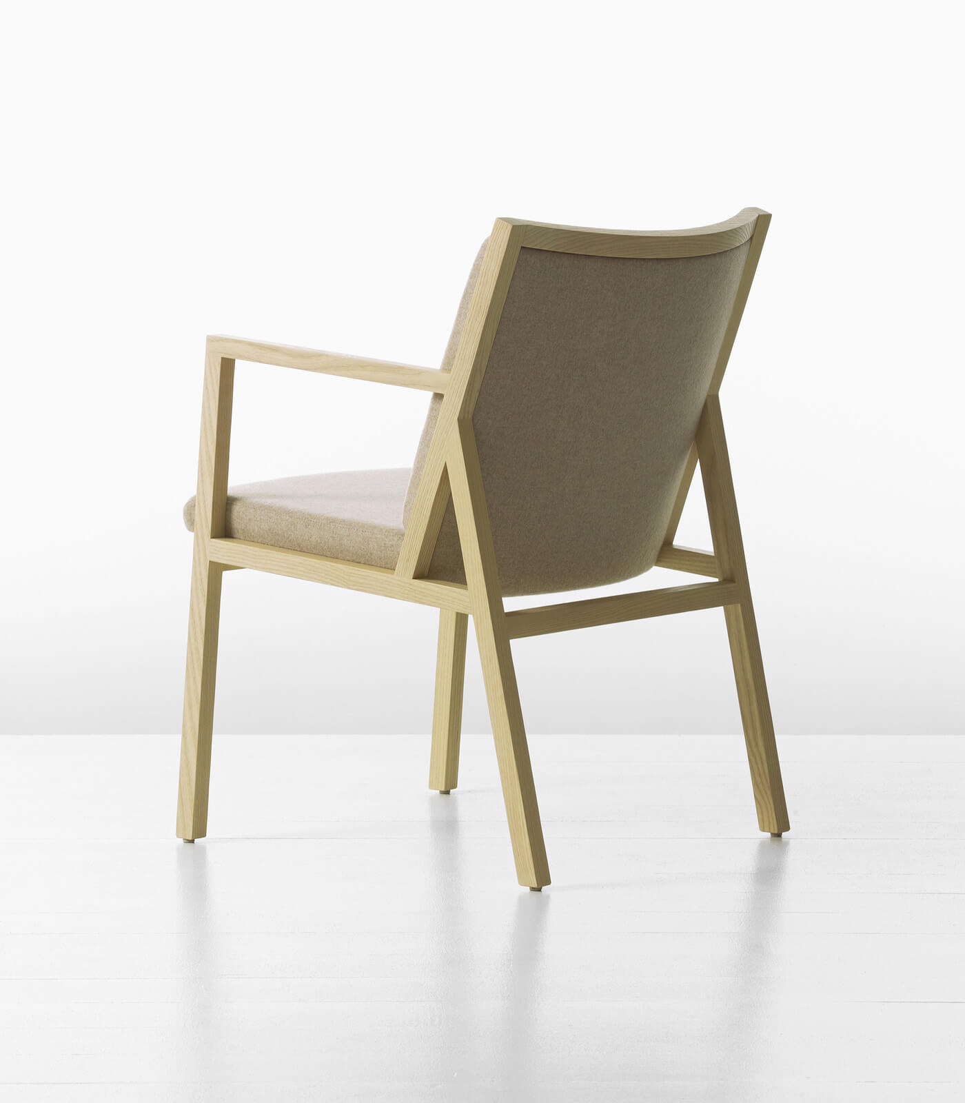 the back side of a ascribe side armchair in white wood in a whit room