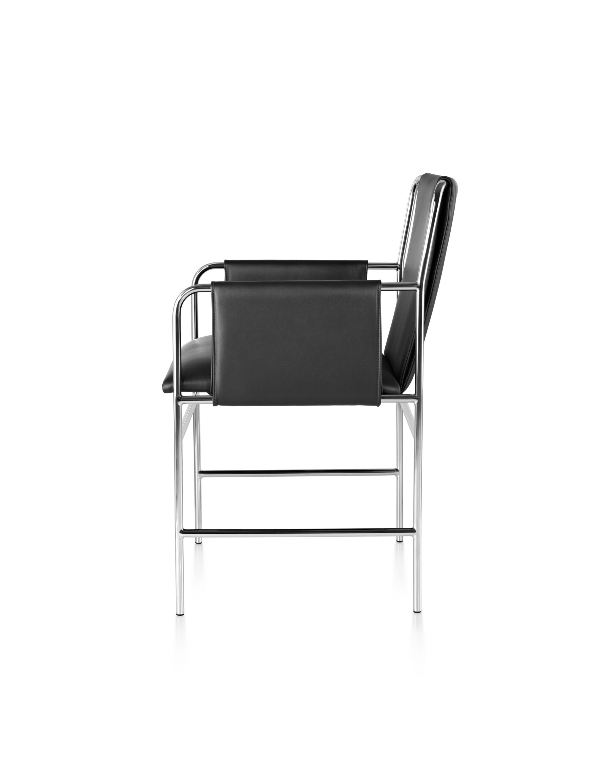 the left side angle of an Envelope Side Chair with polished aluminium frame and black leather seat in a white room