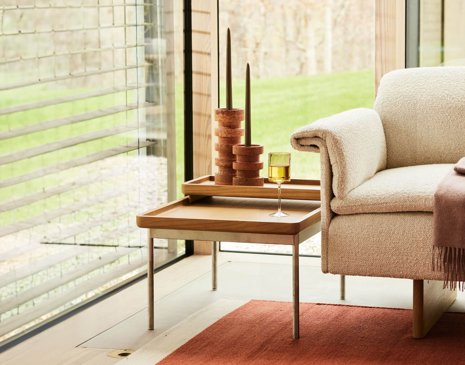 the detail of a tuxedo side table next to a sofa arm and a big window