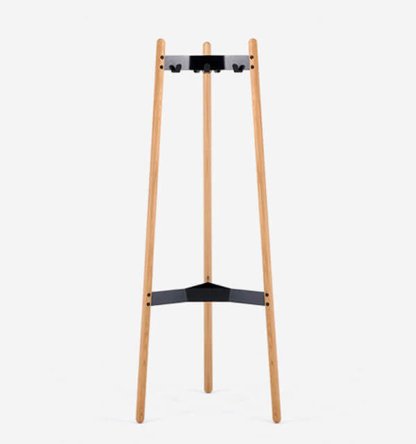 the fron side of a Hudson Coat Stand with wooden legs and metallic frame in a white room