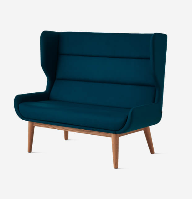 the front side right angle of Hush High Back Sofa, with wooden wire legs in a white room