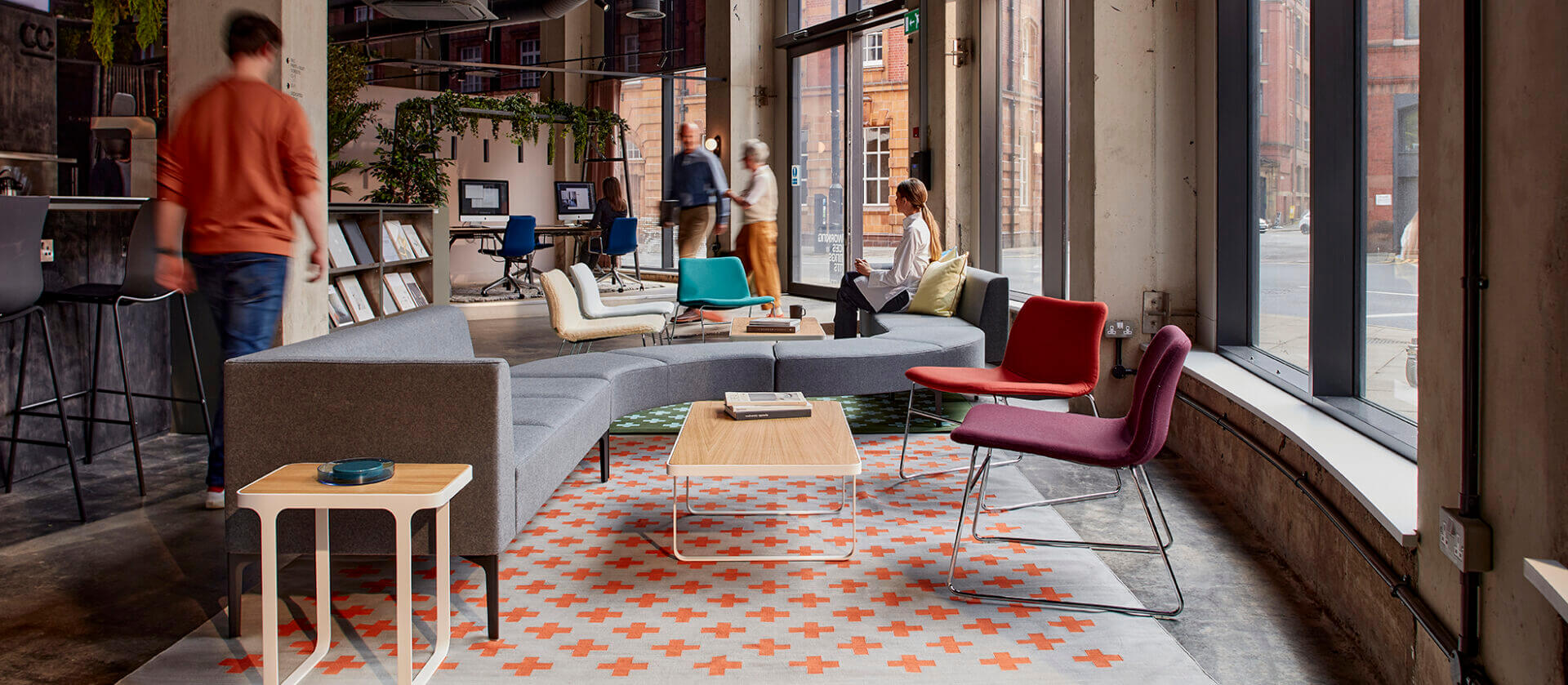 the front side angle of a trace side table in white colour frame and wooden top in a modern commercial space with designer lounge furniture around