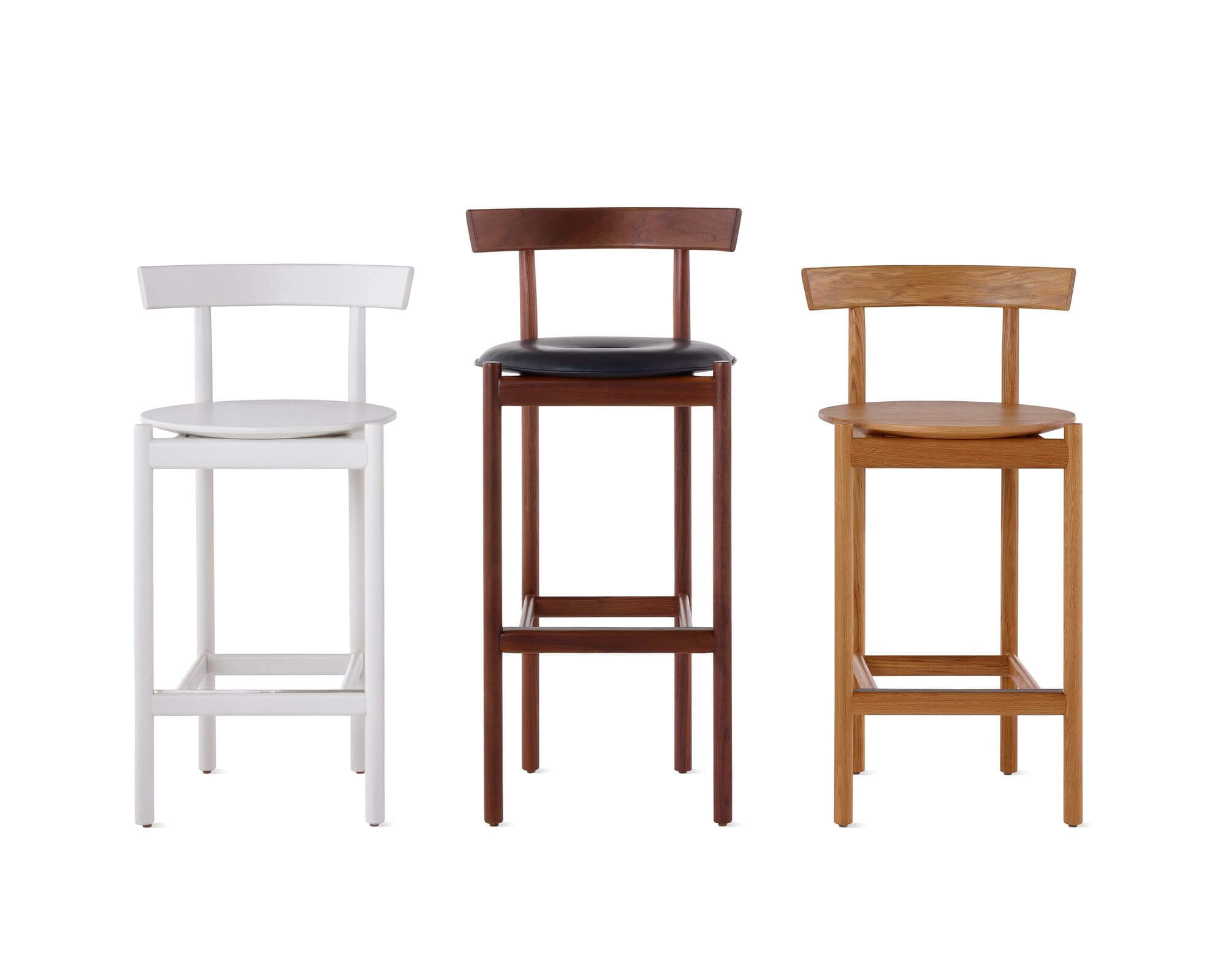 three Comma Wooden Barstools in diferent colours and sizes in a white room
