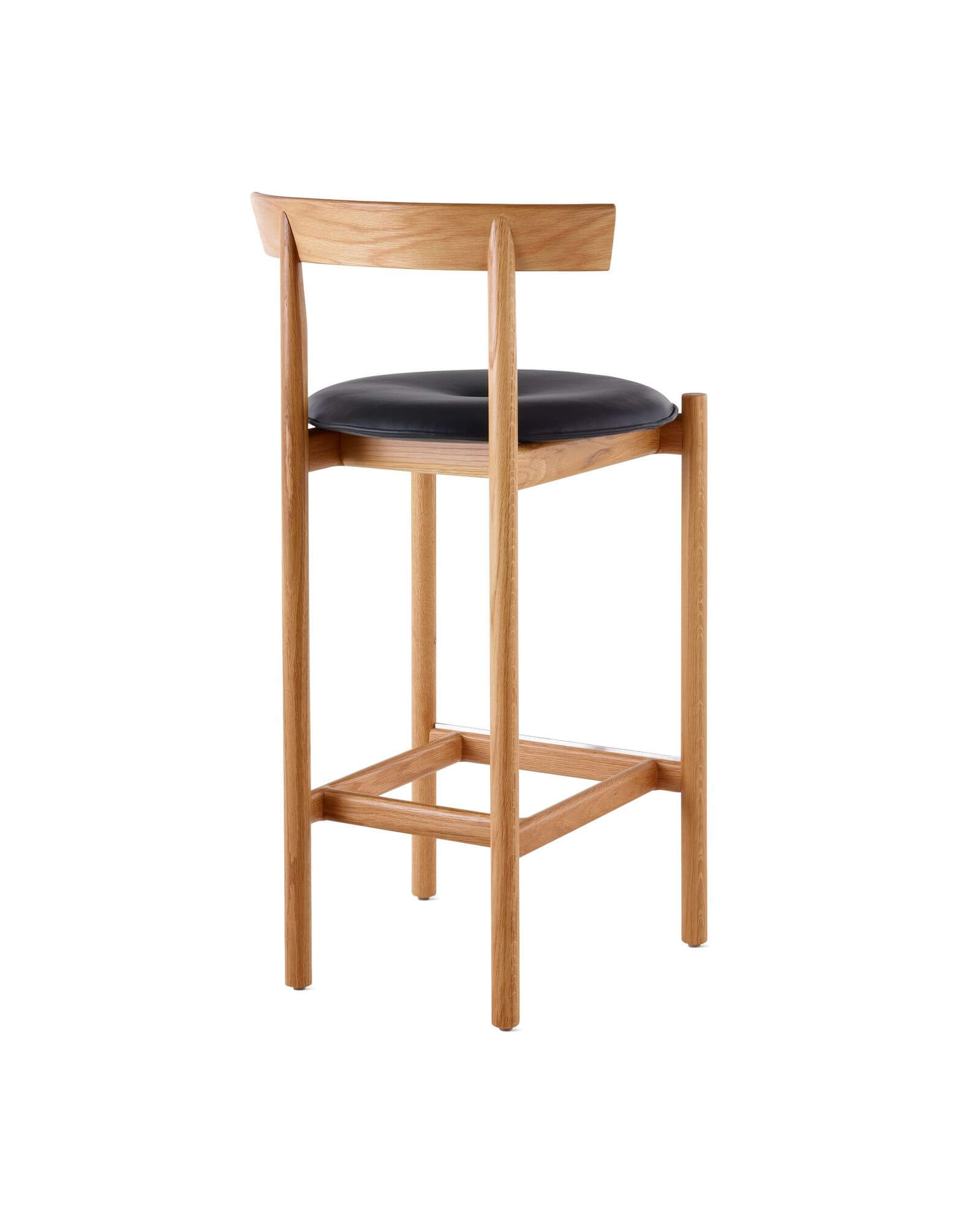 the back side angle of a Comma Wooden Barstool with leather cushion in a white room