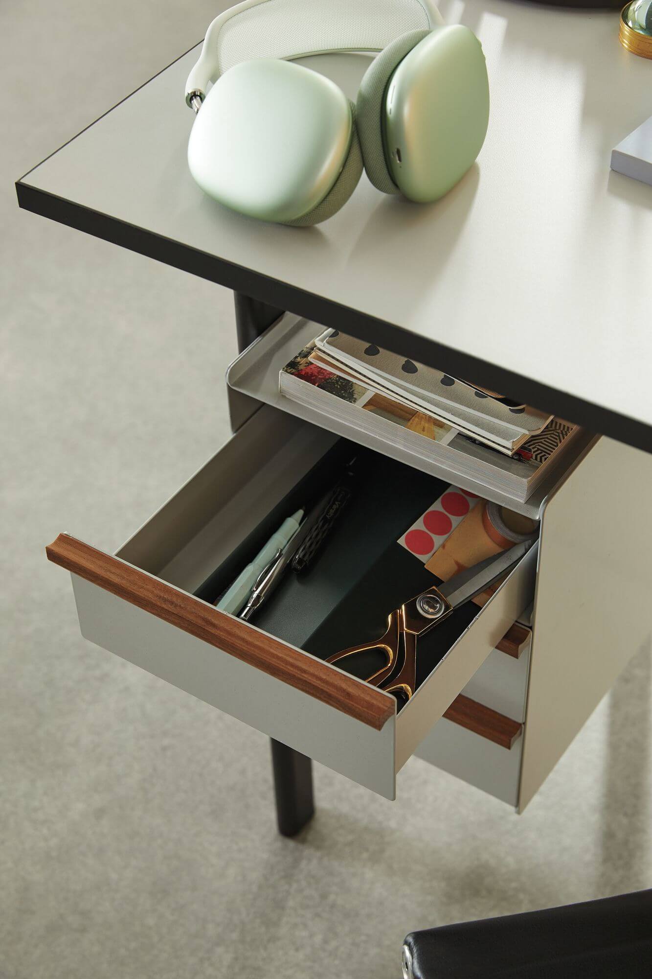 the detail of an open the front side of a Mode Wooden Top Desk drawer in a white room