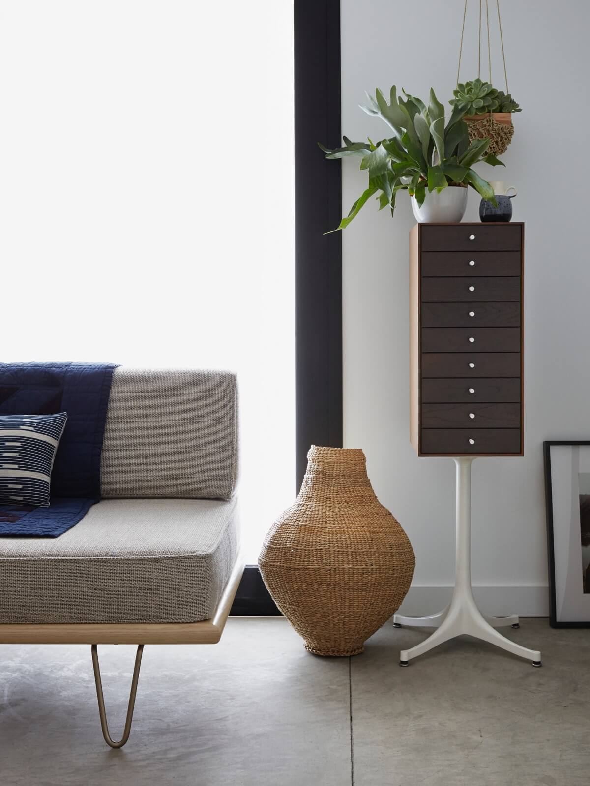 a stylish living room featuring a wooden Nelson Miniature Chests Storage next to a sofa and with a small plat on top