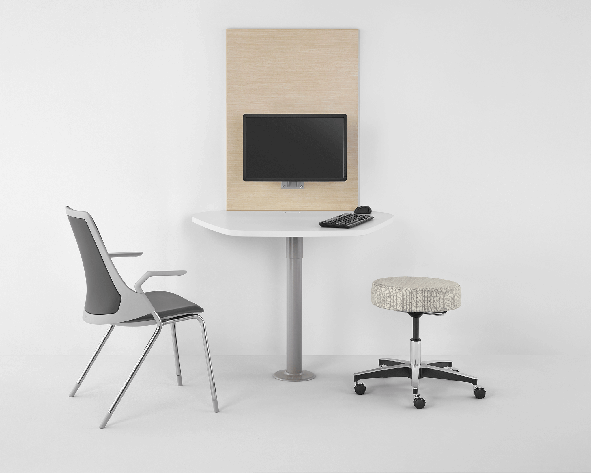 a modern medical practice room featuring a Sayl Side Chair and a stool with castor wheels
