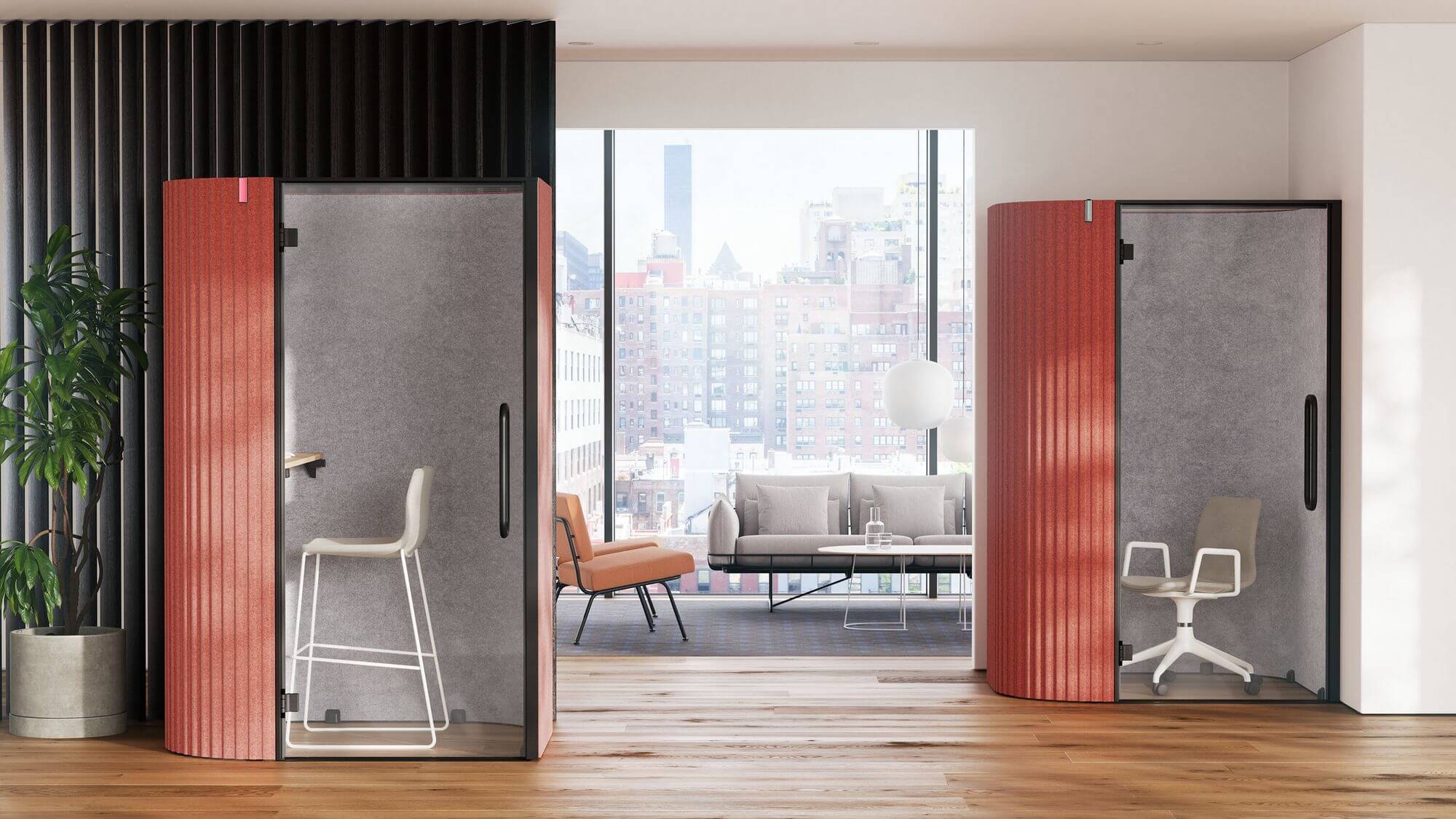 two red work pods and a Wireframe Sofa Group in the background next to a big window