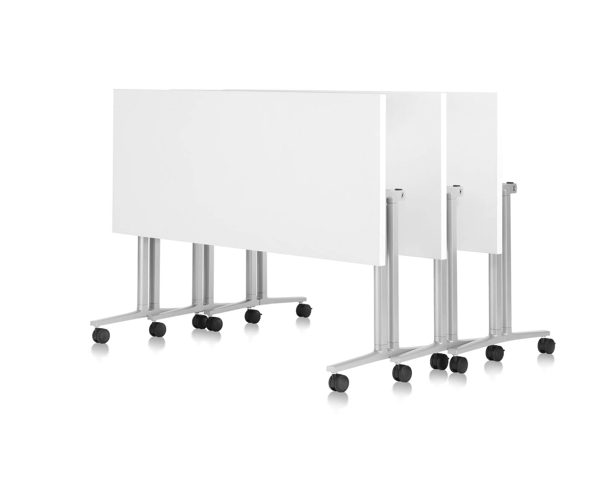 three white top vertically folded Everywhere Multi-Purpose Tables stacked in a white room