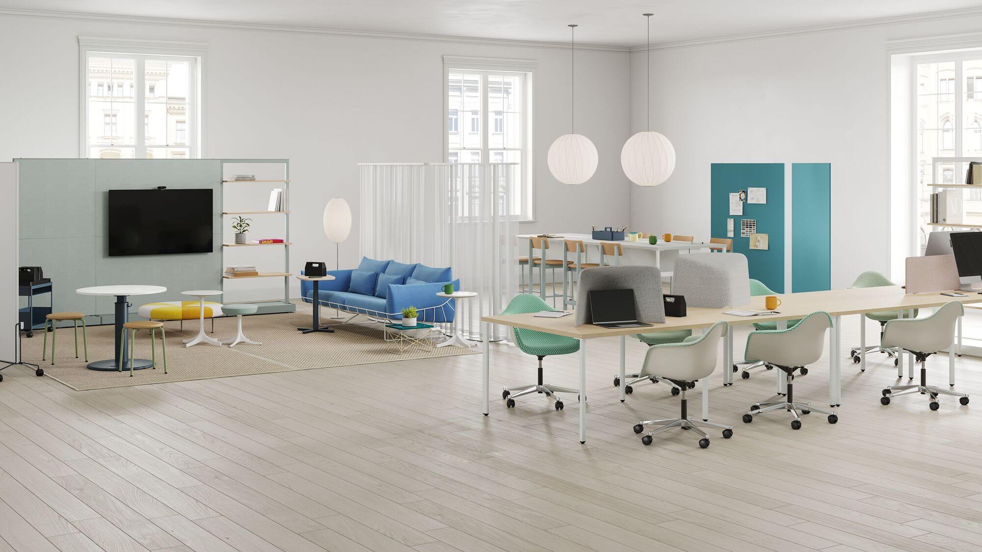 a modern shared office space with a long workstation on the right and a lounge area in the right featuring a Girard Color Wheel Bench Ottoman