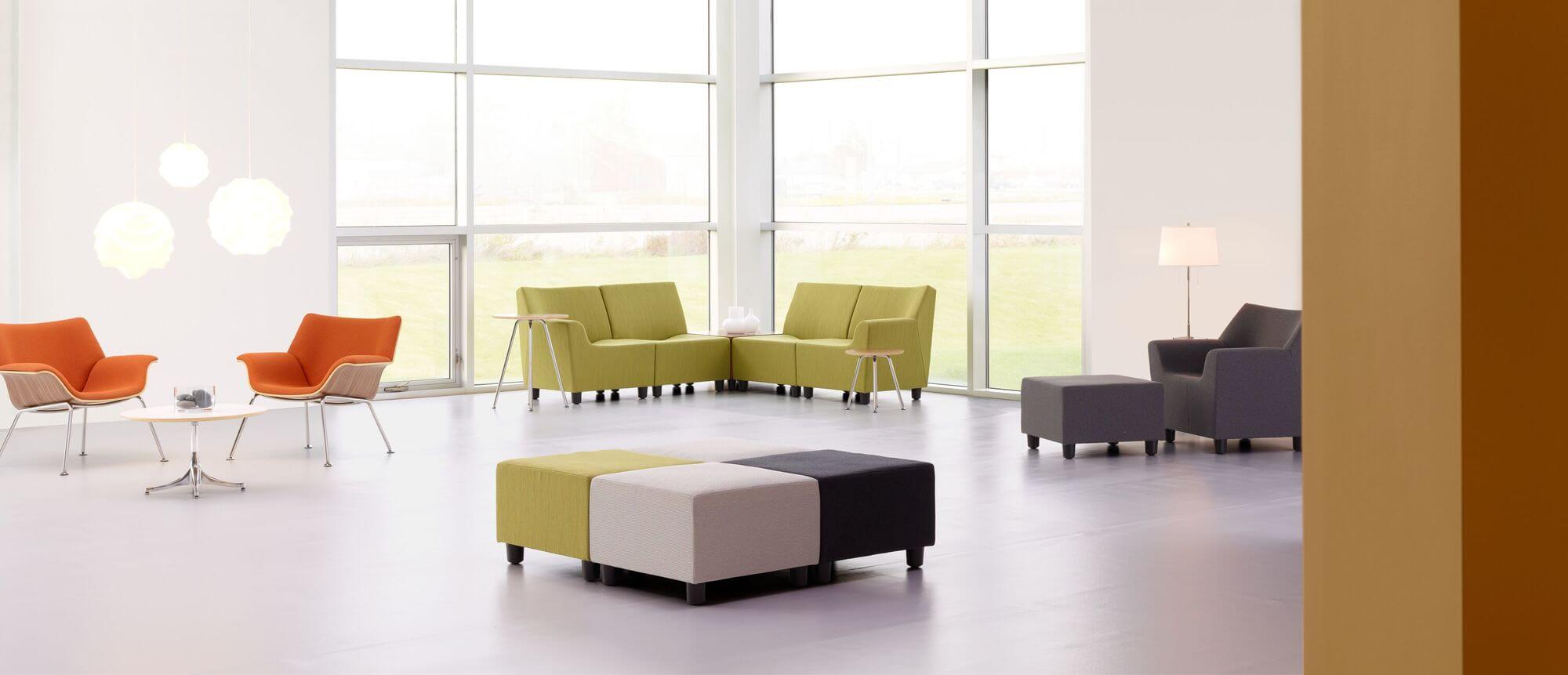 a modern white office lobby featuring colourful furniture with side chairs and Swoop Modular Lounge Sofas