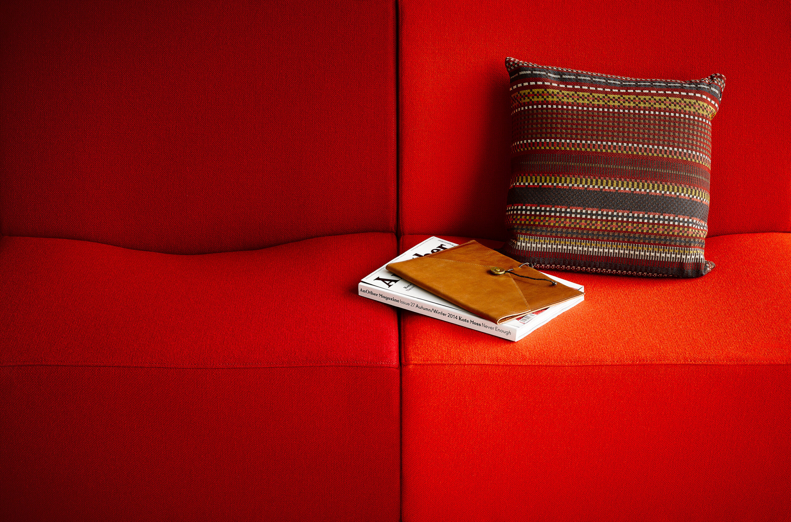 the top detail seat of a Swoop Modular Lounge Sofa with red upholstery and a pillow