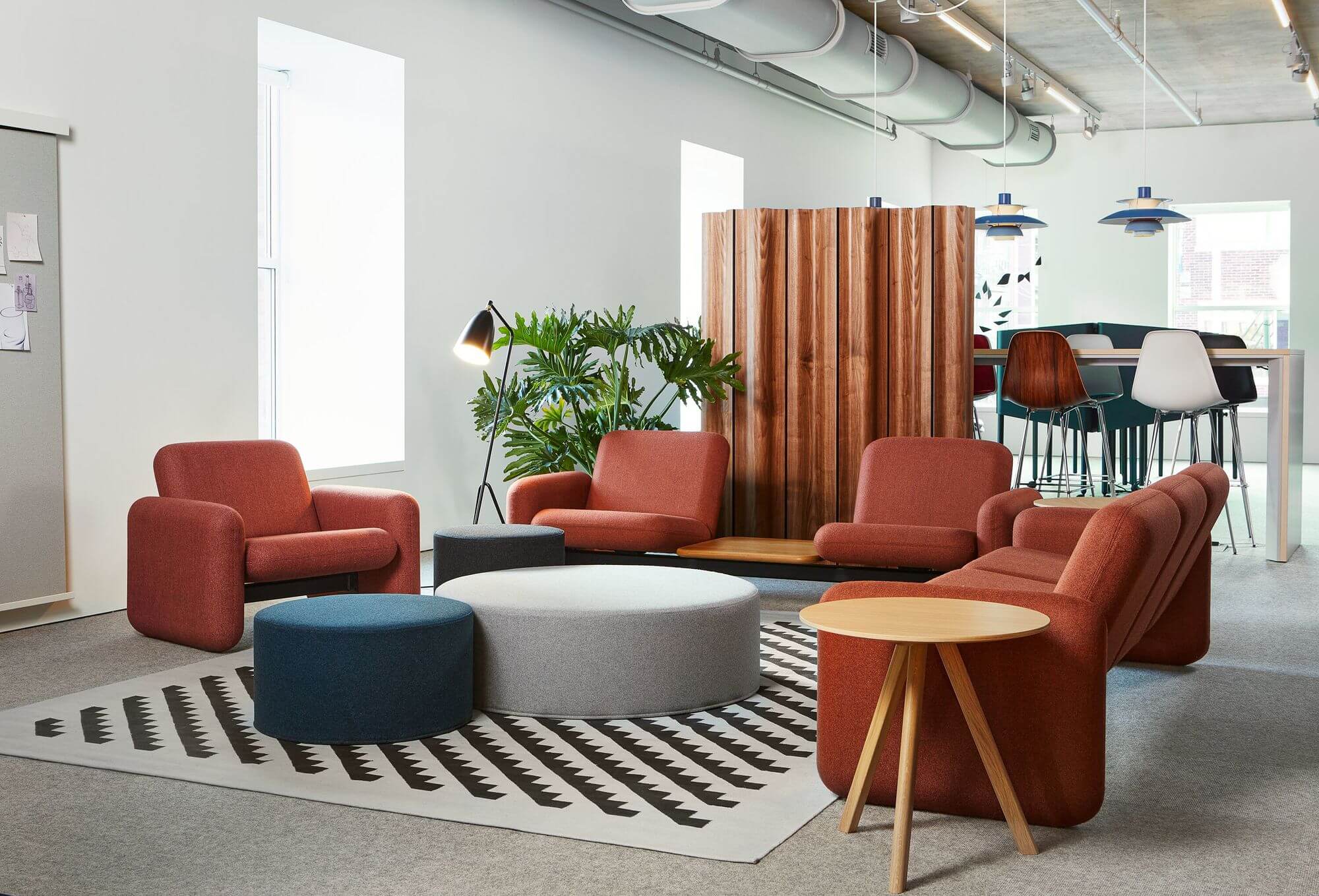 the side angle of a a commercial space with four Wilkes Modular Sofa Group and ottomans in the middle