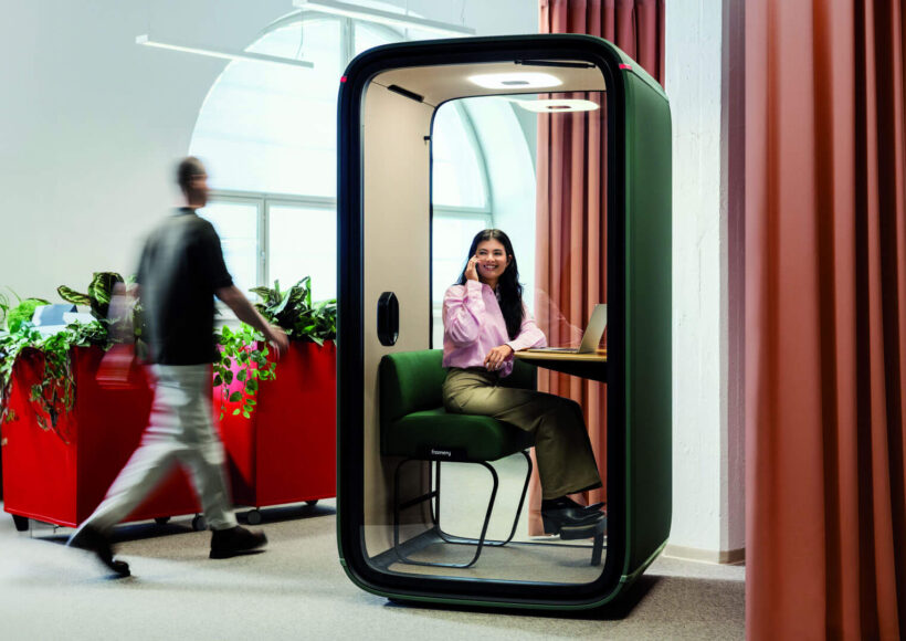 a busy modern austrralian office featuring a framery pod in the middle with a woman inside as a quiet space