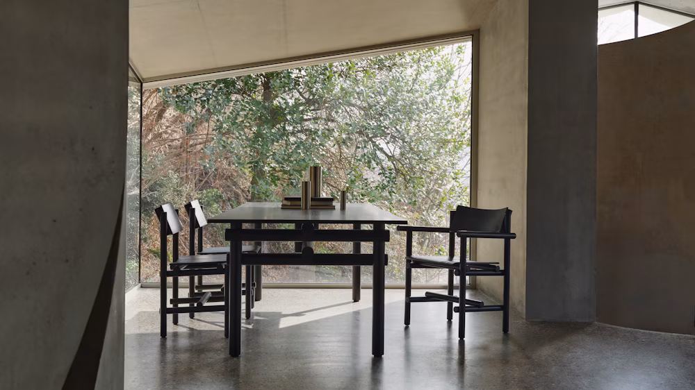 three three Muecke wooden armhairs by knoll in a modern dining room with a big window in the backgroound.