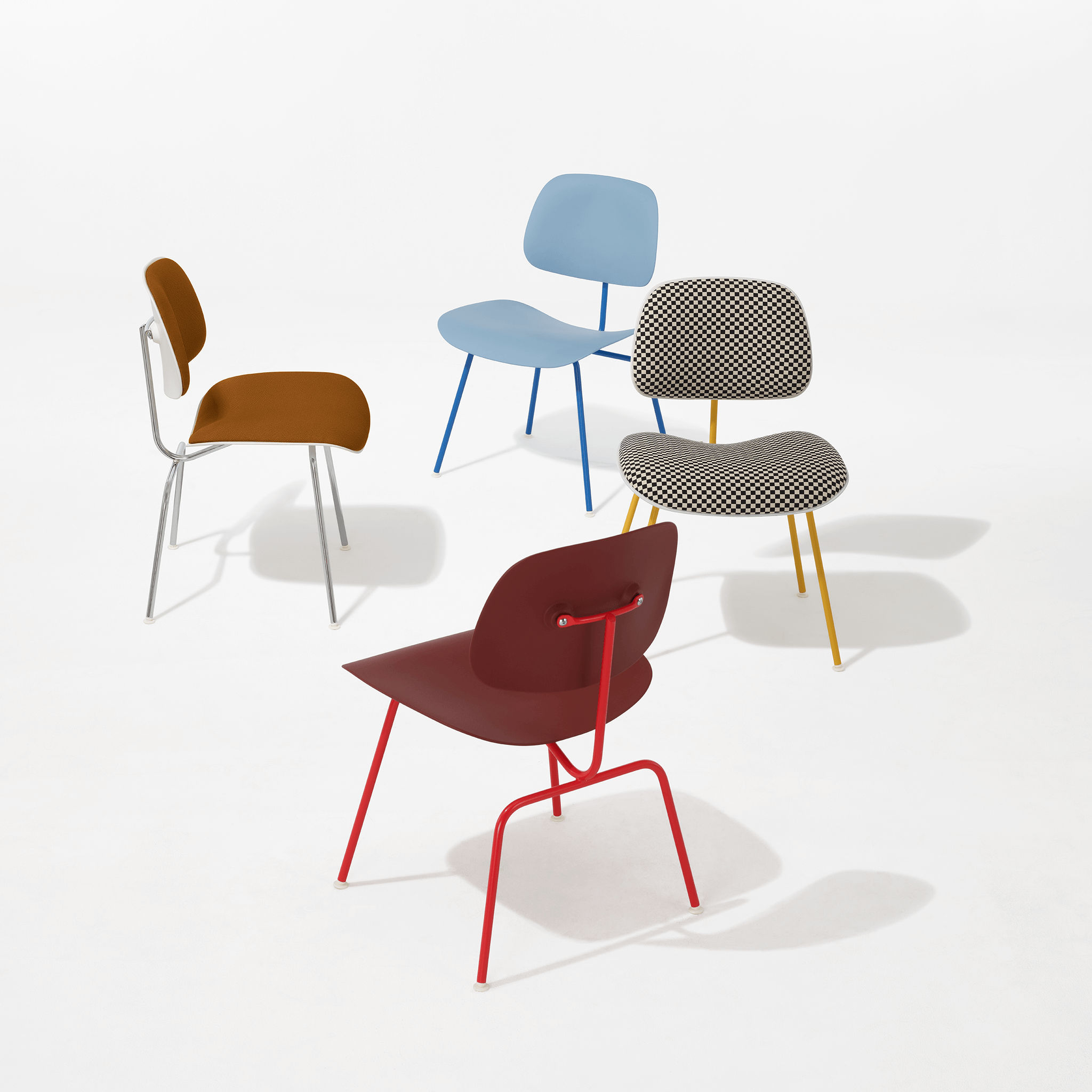 four eames moulded plastic dining chair in various colours in a white room